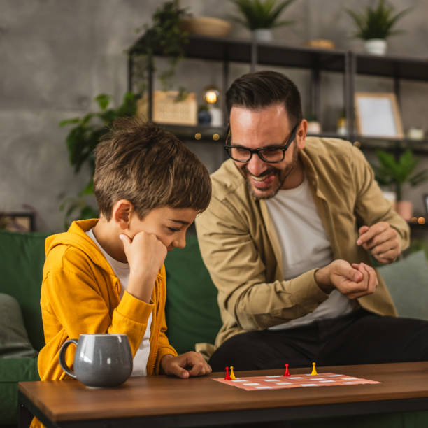 istock Father and son play board game together at home 2150746688