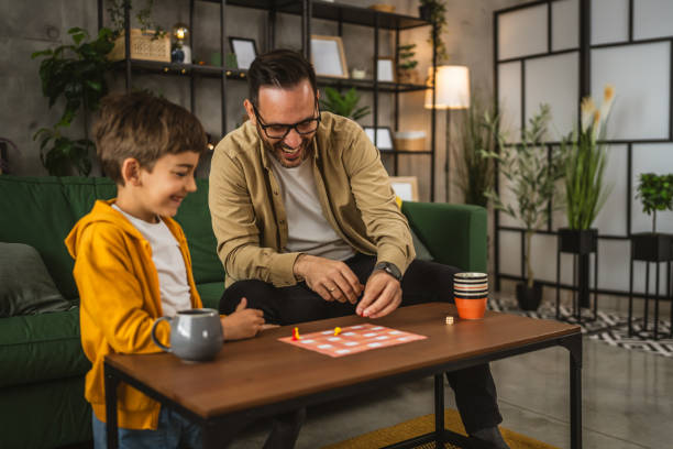 istock Father and son play board game together at home 2150746762