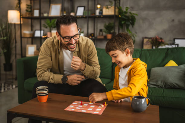 istock Father and son play board game together at home 2150746824