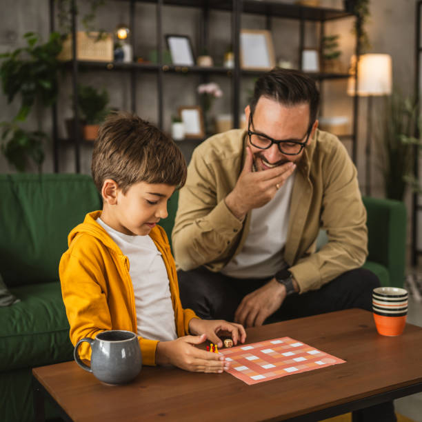 istock Father and son play board game together at home 2150746825