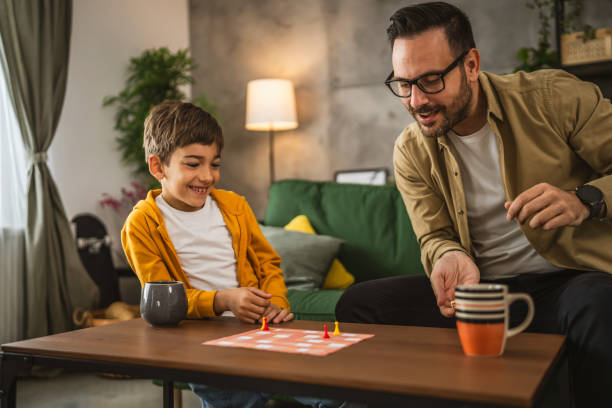 istock Father and son play board game together at home 2150746936