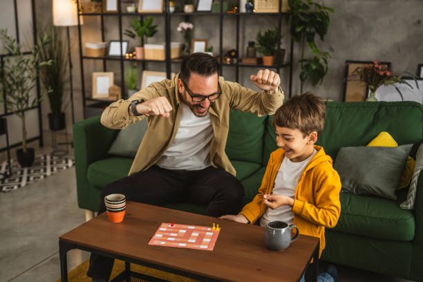 istock Father and son play board game together at home 2150747005