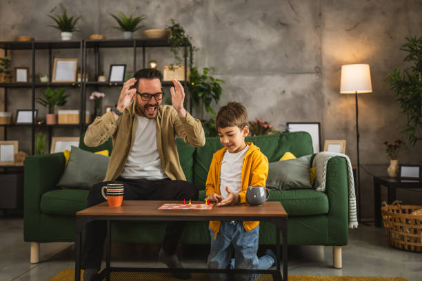 istock Father and son play board game together at home 2150747219