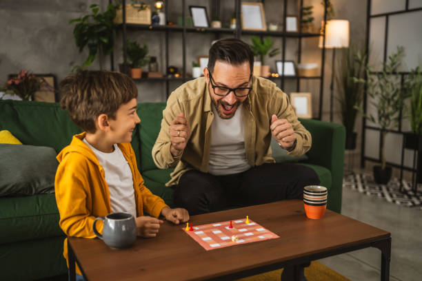 istock Father and son play board game together at home 2150747222