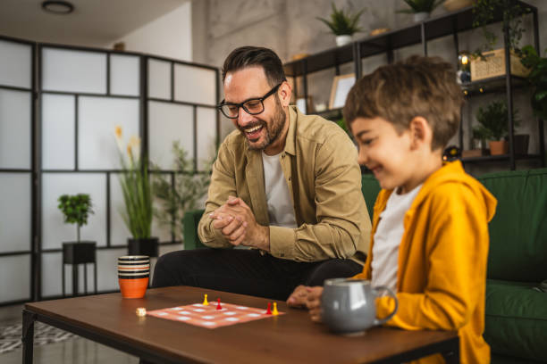 istock Father and son play board game together at home 2150747284