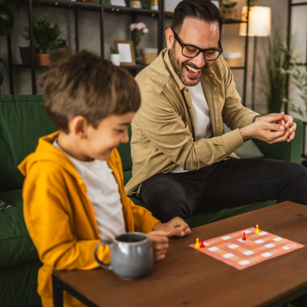 istock Father and son play board game together at home 2150747344