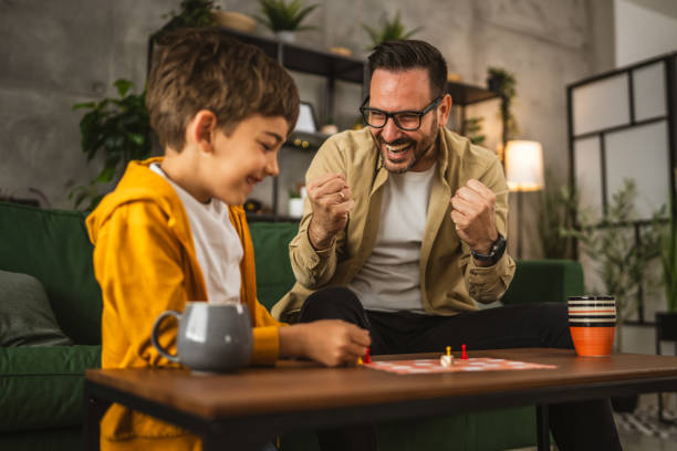 istock Father and son play board game together at home 2150747401