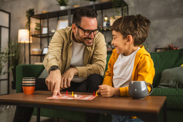 istock Father and son play board game together at home 2150747955