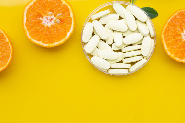 istock Vitamin C pills with  fresh orange citrus fruit isolated on white background. 2150748806