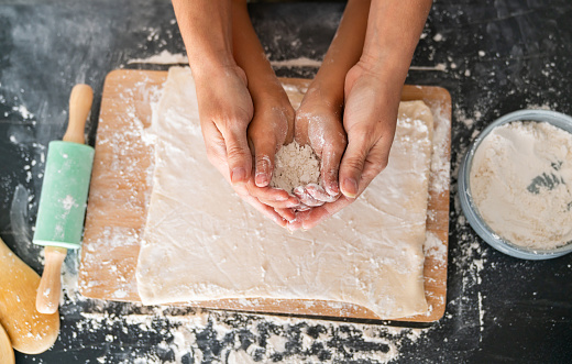 Close-up on the hands of a loving mother and daughter baking together at home