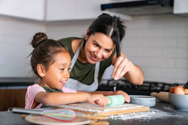 istock Loving mother teaching her daughter while baking at home 2150750457
