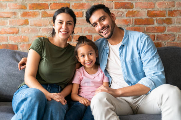 istock Happy family smiling at home while sitting on the sofa 2150750495