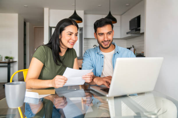 Couple paying utility bills at home using their laptop