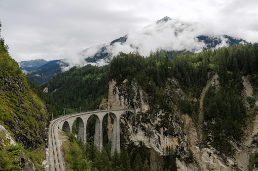 Scenic Landwasser Viaduct in Swiss Alps in summer  with clouds covering the mountain