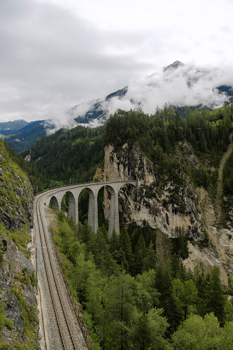 Scenic Landwasser Viaduct in Swiss Alps in summer  with clouds covering the mountain