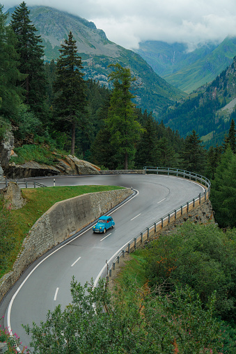 Scenic view of blue vintage car on mountain pass in Swiss Alps