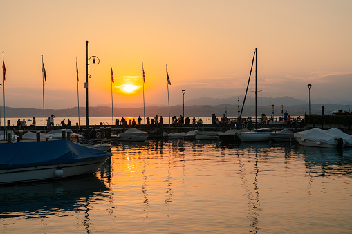 Marina with yachts on lake Garda at sunset in summer
