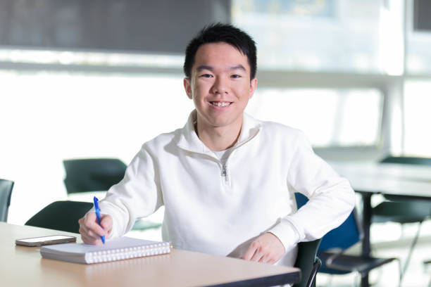 istock A college student is seated at a classroom desk, writing in a notebook 2150751695
