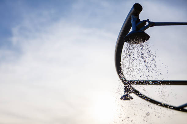 Shower head with water drops on blue sky background