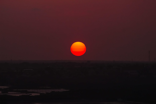 Sunset hour. Big round sun on the horizon of the city of Natal, Rio Grande do Norte, Brazil. Nightfall.