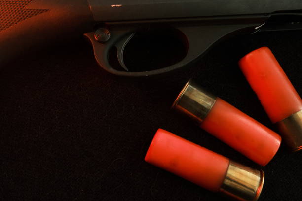 Trigger of a rifle on black background with red lightning with Shotgun shells on a black surface. Ammunition for 12 gauge smoothbore weapons. Hunting ammunition. Dark background