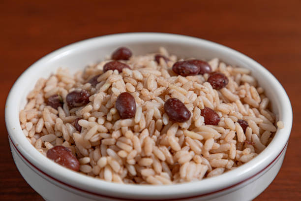 Rustic white dish filled with seasoned rice mixed with beans, diced vegetables, and fresh herbs, showcasing vibrant colors and textures. Great for authentic cuisine, homemade meals, and cultural food themes.