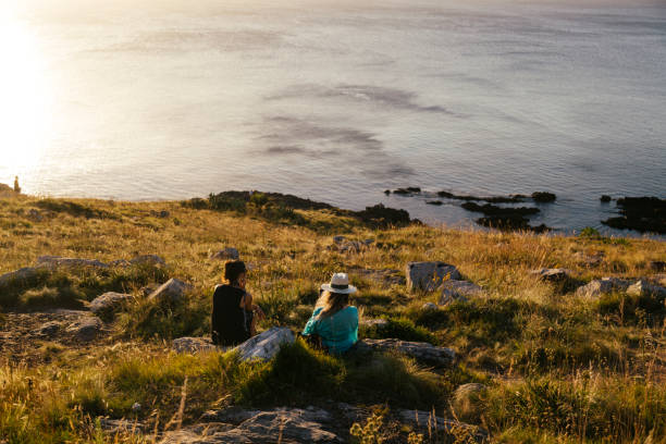 Mother and daughter watch the Atlantic Ocean during sunset hours