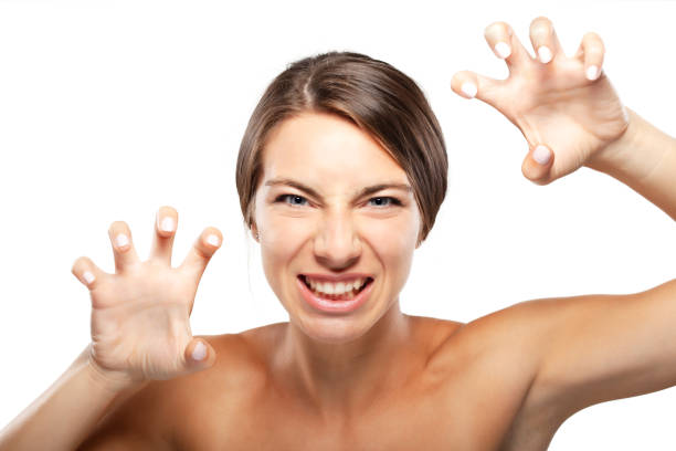 A dynamic studio portrait capturing a young woman playfully gesturing with her hands, showcasing her athletic form and vibrant energy.