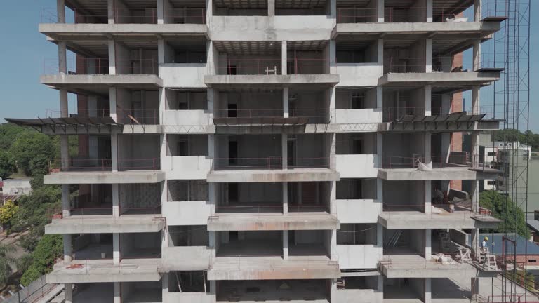 Drone footage traces the progress of a building under construction, view from the top floors to the bustling activity at ground level, capturing every detail of the evolving structure.
