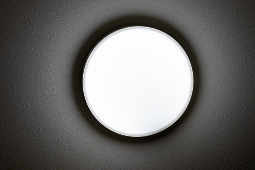 View from directly below of a ceiling light illuminating a dimly lit room