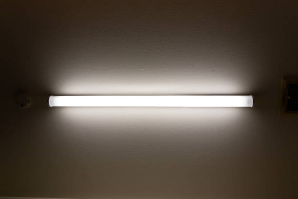 istock A straight tube light on the ceiling illuminates a dark room 2150766515