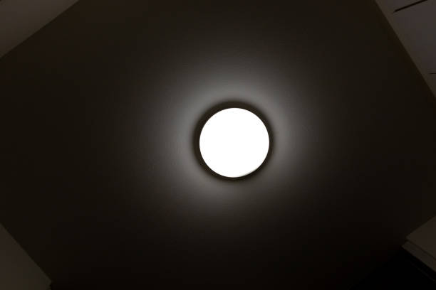 View from directly below of a ceiling light illuminating a dimly lit room