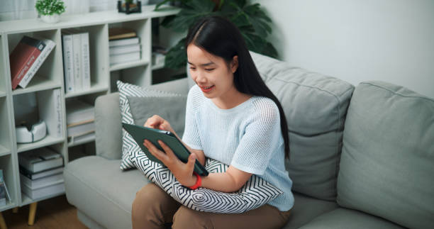 istock Young woman relaxing with digital tablet at home. 2150769503