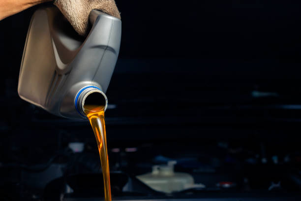 istock Pour engine oil from the lubricant bottle. Engine background, oil change shop engine service industry 2150770772