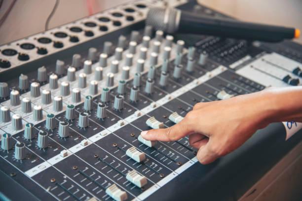 istock Production sound engineer woman hands adjusting volume equalizer voice, mixing console. DJ sound engineering working on recording studio mixing voice control.  Producer remix tune music sound record 2150773380