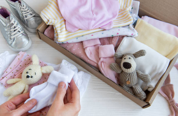 istock Women's hands collect children's clothes into boxes. 2150775014