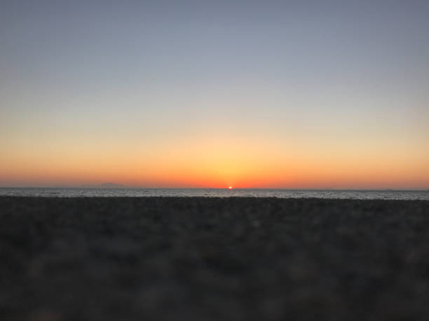 An orange sunset over the ocean is a beautiful sight to see at the time of day when the sun begins to sink below the horizon. The sky takes on an orange or reddish hue, and these colors are reflected off the surface of the ocean as well!