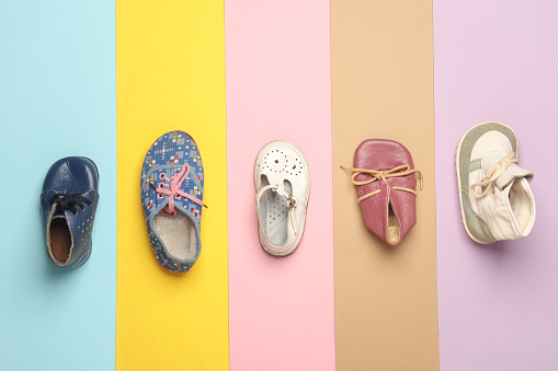 Various children's shoes on a colored background. Top view