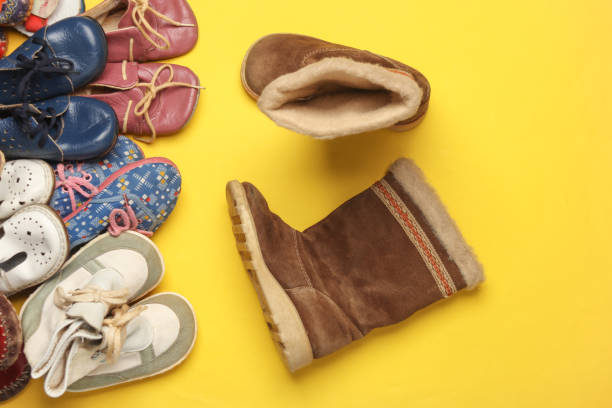 istock Many different children's shoes on yellow background. Top view 2150775197