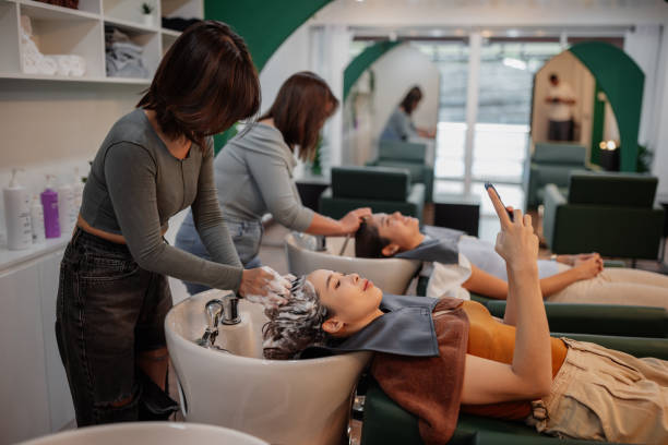 Smiling woman using phone at hair salon