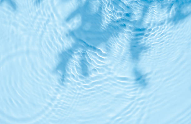 istock Background summer natural blue texture, clear water with ripples and splashes. Water waves in sunlight with leaf shadow, and background concept of cosmetics, moisturizer, and toner concept 2150778266