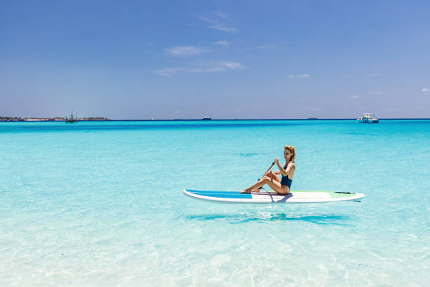 istock Young woman enjoying while paddleboarding in summer day at sea. 2150781587