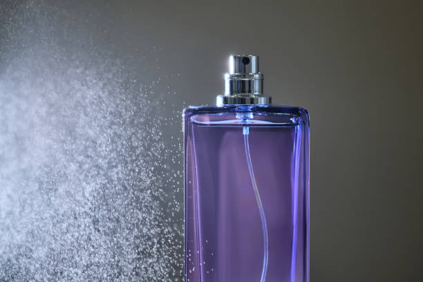 istock Perfume spray in a violet bottle on a dark background. 2150781785