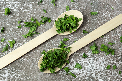 Wooden spoon with green dry parsley. Vegetarian bio organic salad herb healthy eating. Home garden immunity-boosting herbs. Seasonal harvest cottagecore