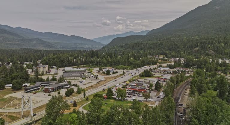 Revelstoke BC Canada Aerial v5 drone flyover Columbia River capturing river crossing bridges, traffics on highway 1 and forested mountain landscape views - Shot with Mavic 3 Pro Cine - July 2023