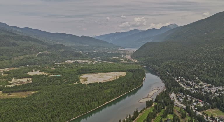 Revelstoke BC Canada Aerial v3 drone flyover residential area capturing Columbia River, riverside golf club course and forested mountain landscape views - Shot with Mavic 3 Pro Cine - July 2023