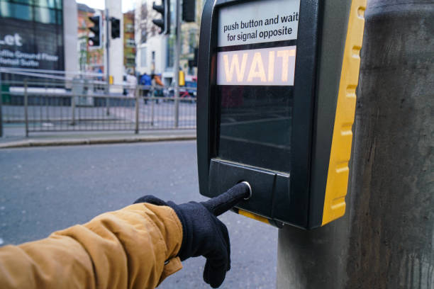 istock Hand finger pressing or pushing on stop request button at crosswalk, Traffic light at square in urban or city 2150785203
