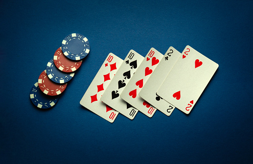 Luck in a casino game with a winning combination of full house or full boat. Playing cards and chips are laid out in a poker club on a blue table.