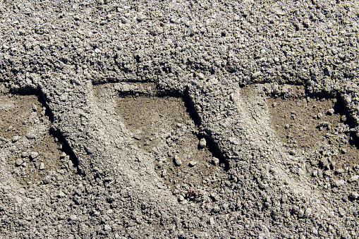 Close-up of large car tracks on a dirt road.