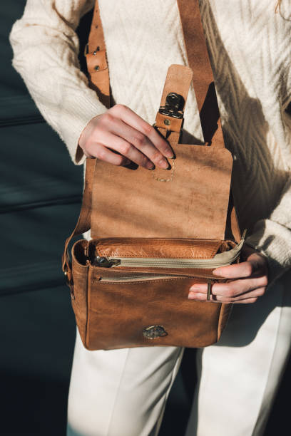 istock beautiful woman posing with a empty small brown bag near grey wall 2150786448